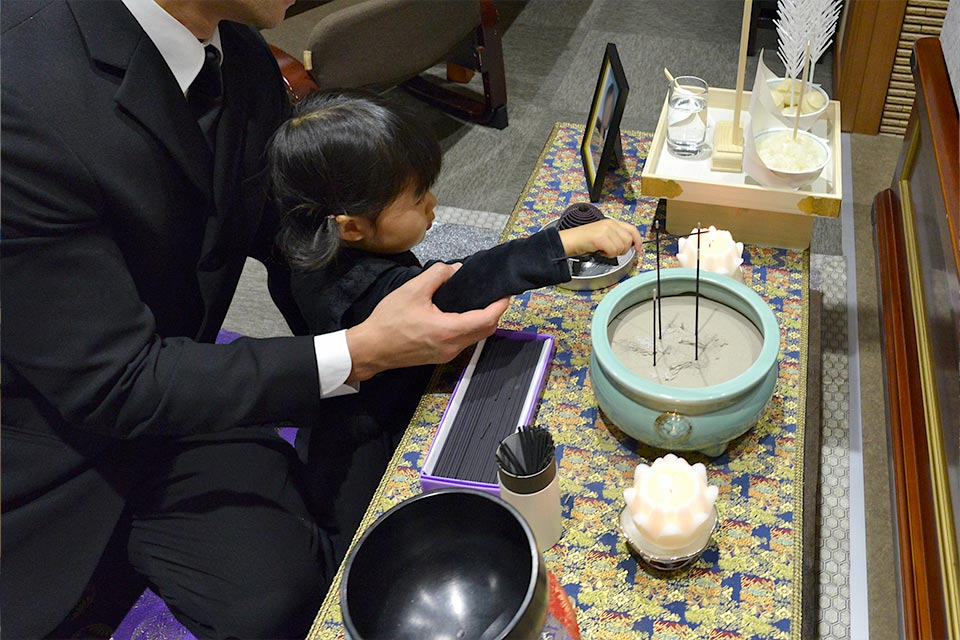 子供がお焼香をしている様子