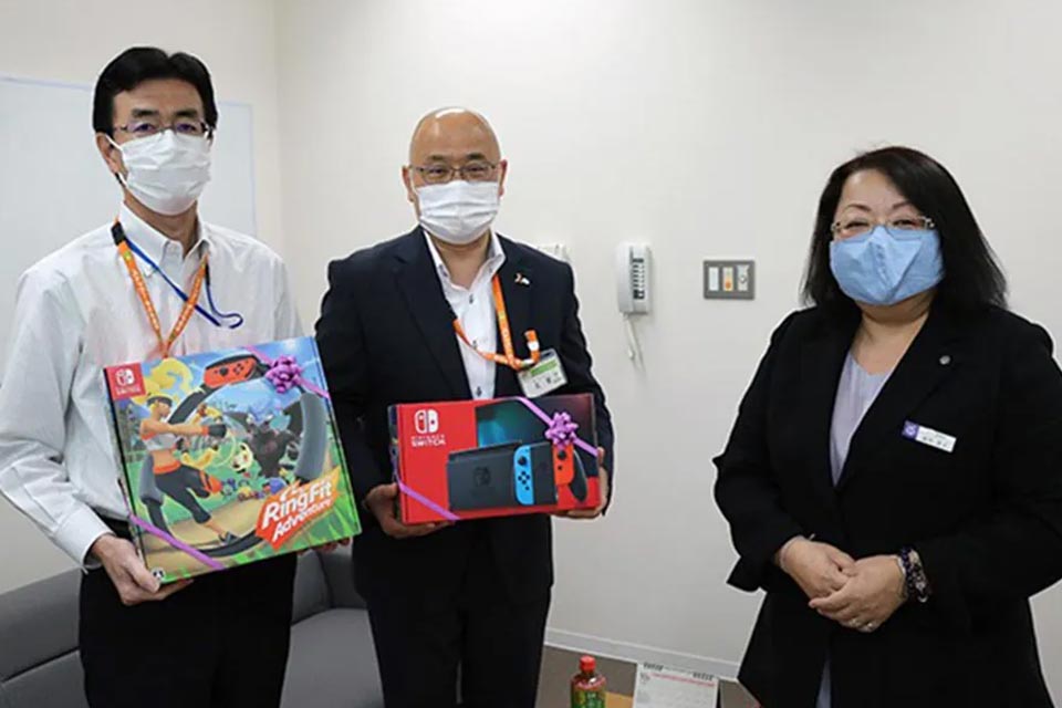 株式会社博愛社がさいたま市で児童相談所へゲーム寄贈する寄贈式の様子、職員が贈呈箱を持って並ぶ